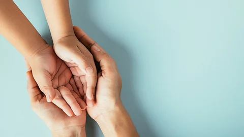 Offene Hände von Mutter und Kind, die ineinander ruhen
